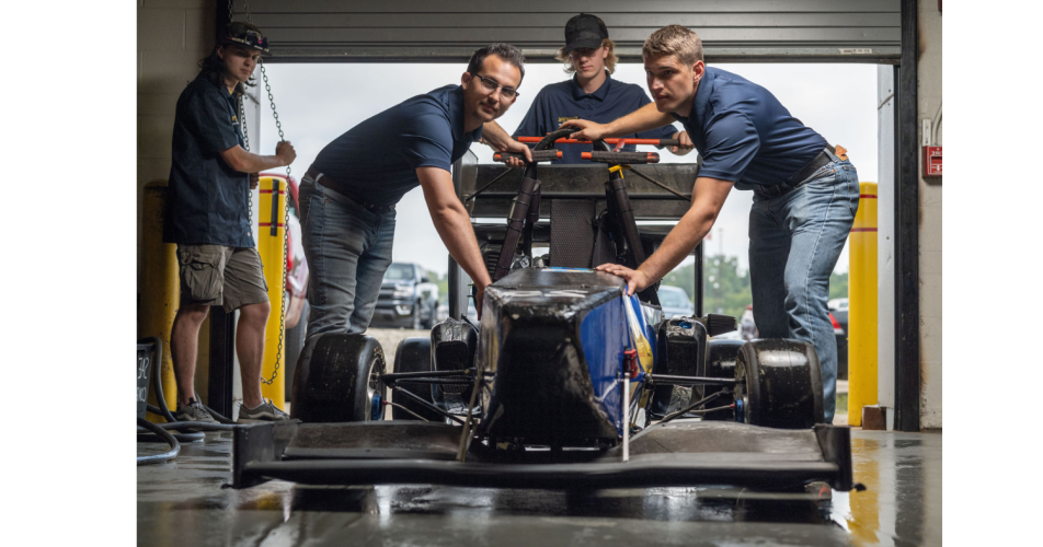 Students pushing car